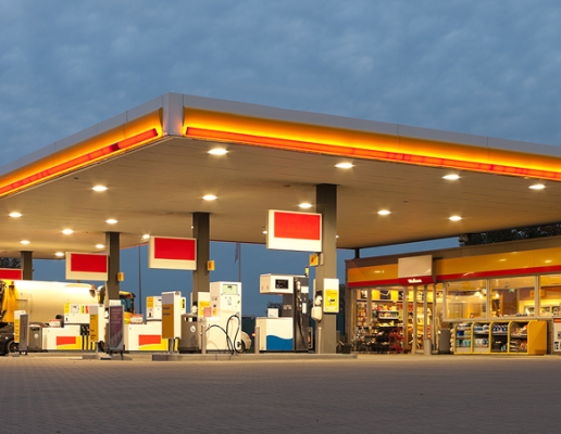 Autobahn Tank & Rast service station at dusk, featuring a sustainable architectural design.